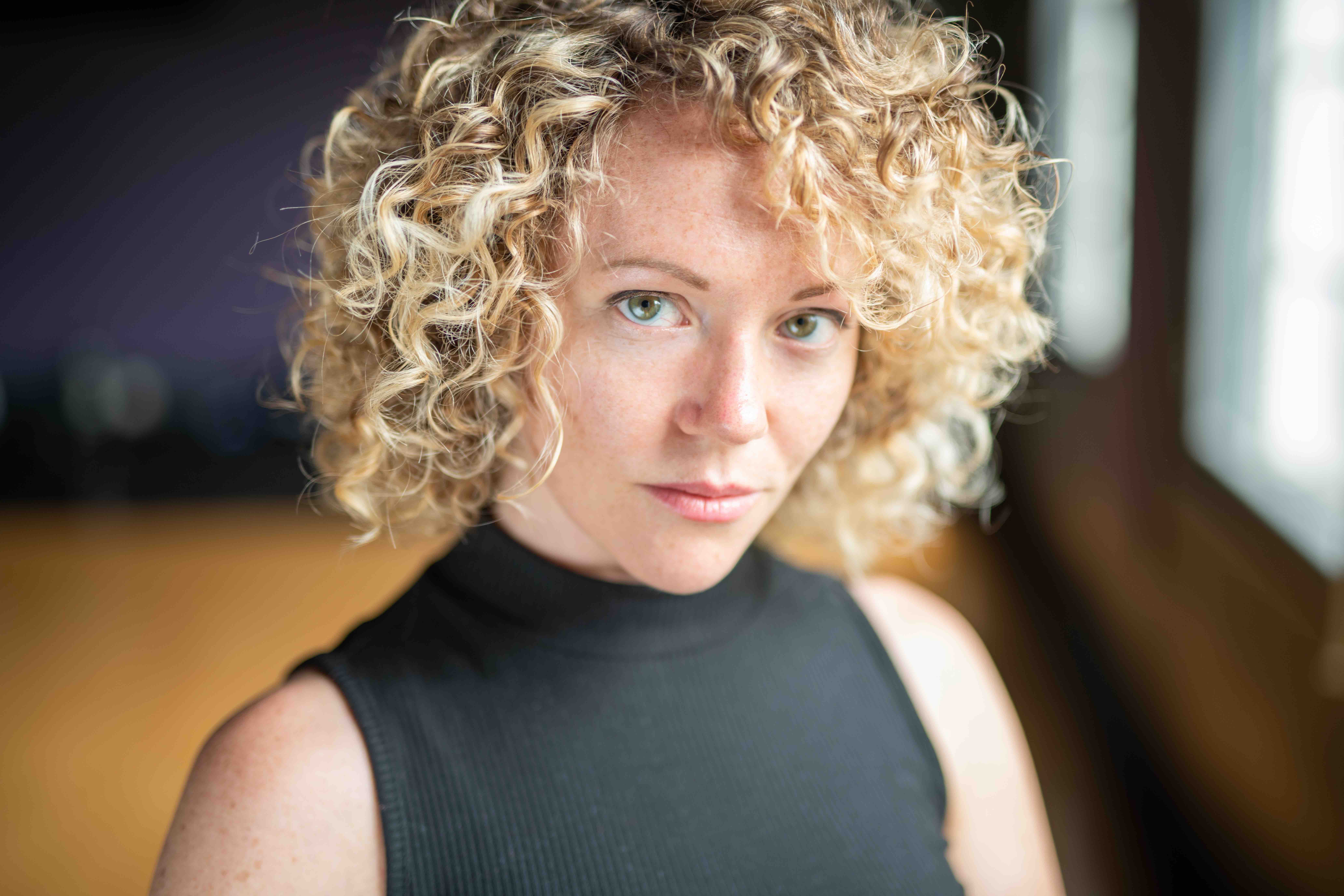 Courtney Abbott, a woman with curly blonde hair and blue eyes.